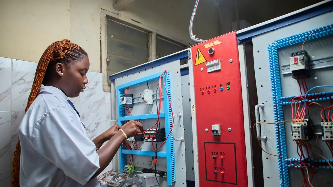 Técnica trabajando en un tablero de control eléctrico